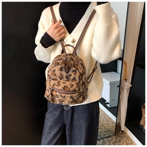 Détail de la texture en fausse fourrure léopard et bandoulière en cuir du sac à dos