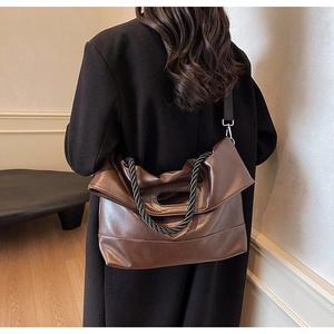Detail showing the dark brown leather texture and black and white braided rope strap