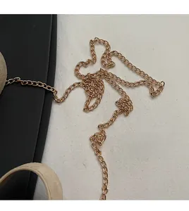 Detail of premium golden metal chain strap on beige soft leather handbag texture