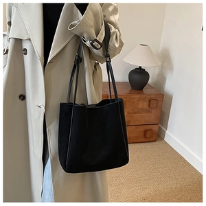 Sac cabas minimaliste en cuir PU noir mat présenté dans une scène lifestyle