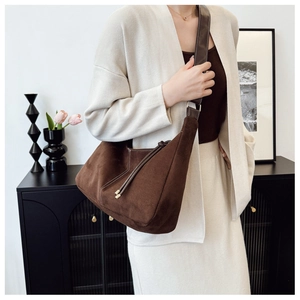 Detail of vintage brown suede Hobo bag featuring white contrast stitching and side tassels