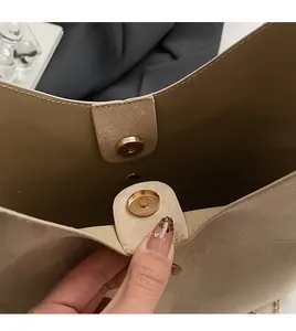 Detail view of the premium golden magnetic buckle on the beige soft PU leather handbag