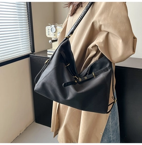 Detail der großen schwarzen PU-Hobo-Tasche mit seitlicher Schnalle und goldener Hardware