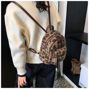 Détail de la texture en fausse fourrure léopard et des bretelles en cuir marron du sac