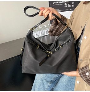 Detailansicht der schwarzen Commuter-Tasche mit mattem Stoff und goldenen Metallteilen