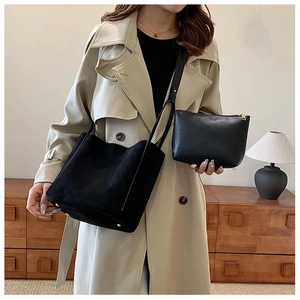 Détail d'un cabas noir en cuir PU avec pochette assortie portée à l'épaule pour femme