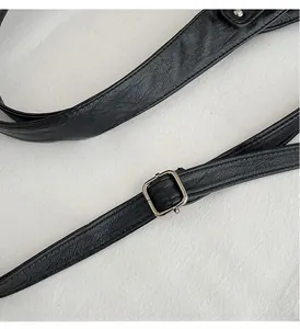 Detail of adjustable black lychee texture leather strap with silver square metal buckle
