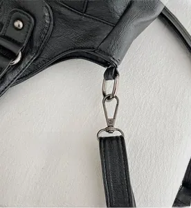 Detail of detachable retro silver metal hook and black lychee grain leather on handbag
