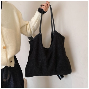 Detail of black faux fur tote bag with leather straps on a model for autumn style