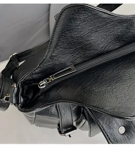 Detail shot of the high-quality silver metal zipper on a black lychee texture PU leather bag