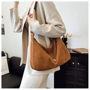 Detail of caramel hobo bag featuring white contrast stitching and tassel drawstring