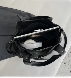 Interior view of large black PU tote showing spacious compartments and laptop sleeve