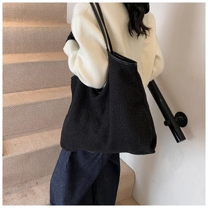 Detail of black faux fur tote bag showing fluffy texture and slim leather straps