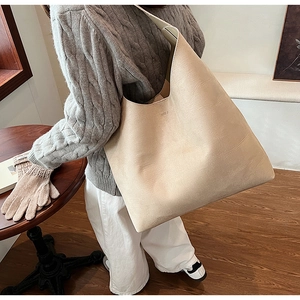 Close-up of beige soft PU leather tote bag with subtle brand logo and pebbled texture