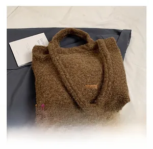 Close-up of brown plush tote bag with soft teddy fleece texture and leather logo patch