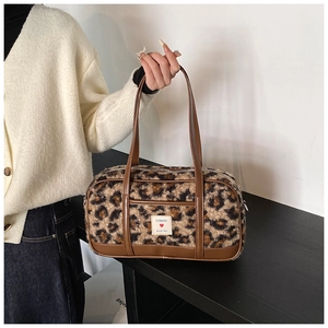 Detail view of leopard print plush handbag with brown leather straps and EUNBUFO logo patch