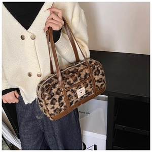 Detail of leopard print plush pillow bag with brown straps and white logo label