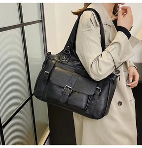 Detail of black faux leather tote bag with three flap pockets and vintage metal buckles