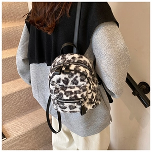Détail d'un petit sac à dos en fausse fourrure léopard avec des bretelles en cuir noir