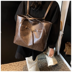 Retro brown leather tote and backpack shown on model in a cozy interior scene