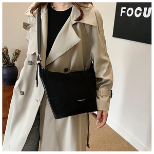 Detail of minimalist black PU leather shoulder bag with FASHION & BAGS logo on a model
