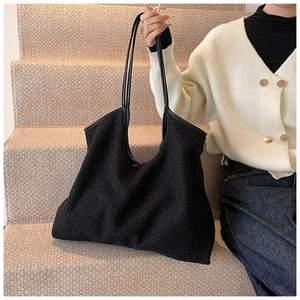 Close-up of black textured faux fur tote bag with slim leather shoulder straps