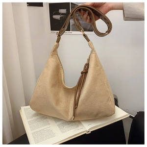 Minimalist beige hobo bag with brown strap for women in a lifestyle indoor setting