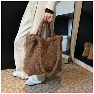 Detail view of brown plush tote bag with soft faux fur texture and dual handle design