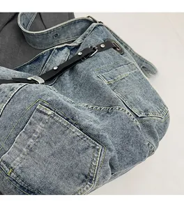 Close-up of vintage blue washed denim tote bag showing detailed stitching and metal buckles