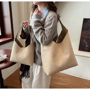 Beige PU leather tote and handbag set worn by model in a cozy indoor home setting
