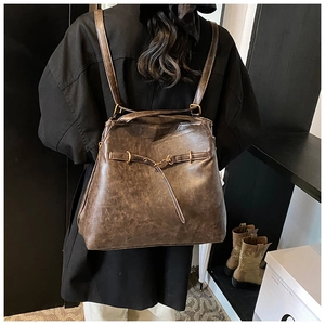 Detail view of retro coffee wax leather backpack with vintage metal buckles on model back