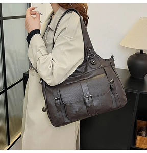 Close-up of vintage brown PU leather tote bag with functional buckle pocket detail