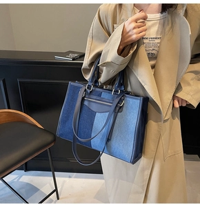 Detail of patchwork denim tote bag featuring adjustable shoulder strap and leather trim edges