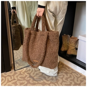 Detail showing the brown plush lamb wool texture and brand label of this large tote bag