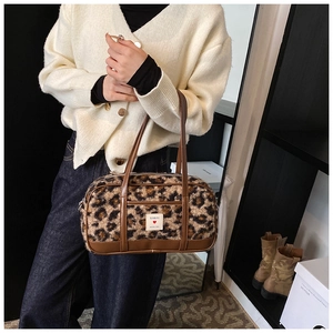 Detail of leopard print plush handbag with brown faux leather trim and heart patch