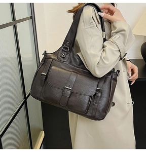 Detail view of coffee brown PU leather tote with vintage decorative buckle straps