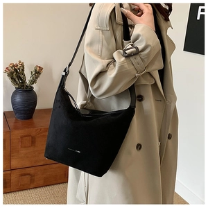 Detail of black matte PU leather hobo bag with adjustable strap on a trench coat model