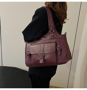 Detailed side view of vintage wine red PU leather tote bag with stylish silver metal buckles
