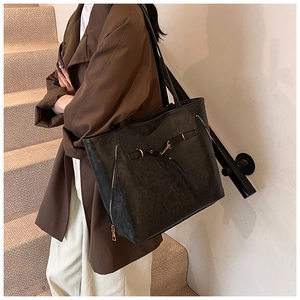 Detail view of vintage black oil-wax leather tote with metallic ring and zipper accents