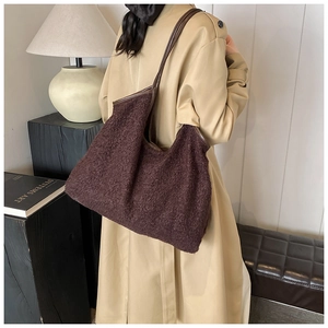 Deep brown teddy plush tote bag shown on model with autumn coat for a stylish daily look