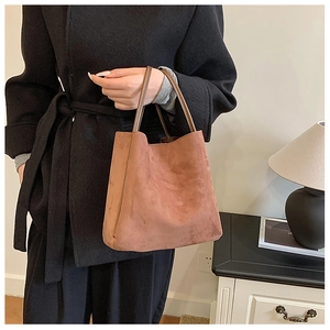 Détail du sac cabas vintage rouge brique en faux daim avec fines anses en cuir