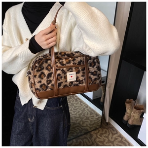 Detail view of leopard print plush handbag with premium brown faux leather trim and top handles