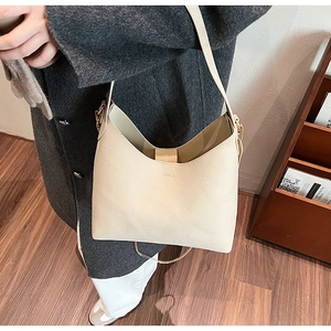 Close-up of beige VEILA faux leather tote bag worn with a grey winter coat