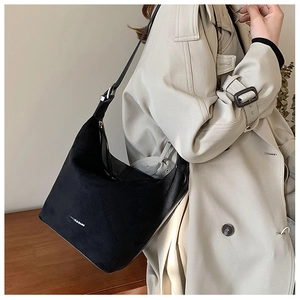 Detail of black suede hobo bag with white Fashion & Bags text print on the side