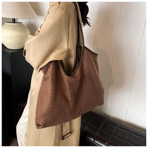 Detail view of large tote bag in caramel faux shearling with leather trim accents