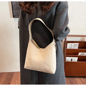 Close-up of cream soft PU leather hobo bag with wide strap and decorative metal chain detail
