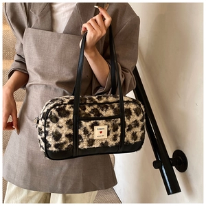 Detailed view of leopard print plush texture with premium black PU leather trim and brand label