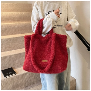 Detail of red plush tote bag made from soft fleece material in a casual commute style