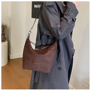 Detail of large brown suede hobo bag with adjustable silver buckle and fashion text