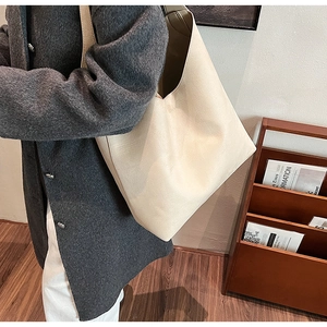 Detail view of cream white PU leather tote bag with soft texture and elegant V-shaped cut
